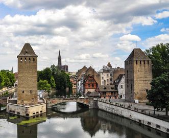 Ansicht auf zwei Türme der Gedeckten Brücken (Ponts couverts) in Straßburg, Teil der ehemaligen Stadtbefestigung am Eintritt der Ill in das Stadtzentrum, im Hintergrund der Münsterturm